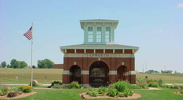 Brick structure with 'EPWORTH' sign and an American flag nearby.