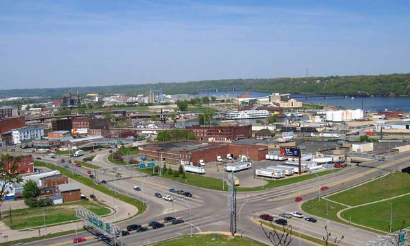 Aerial view of a roadway intersection and industrial area near a river.