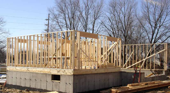 Wooden framework of a house under construction on a concrete foundation.