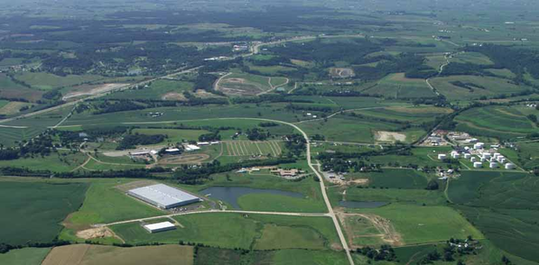Aerial view of a rural landscape with fields, roads, and buildings.