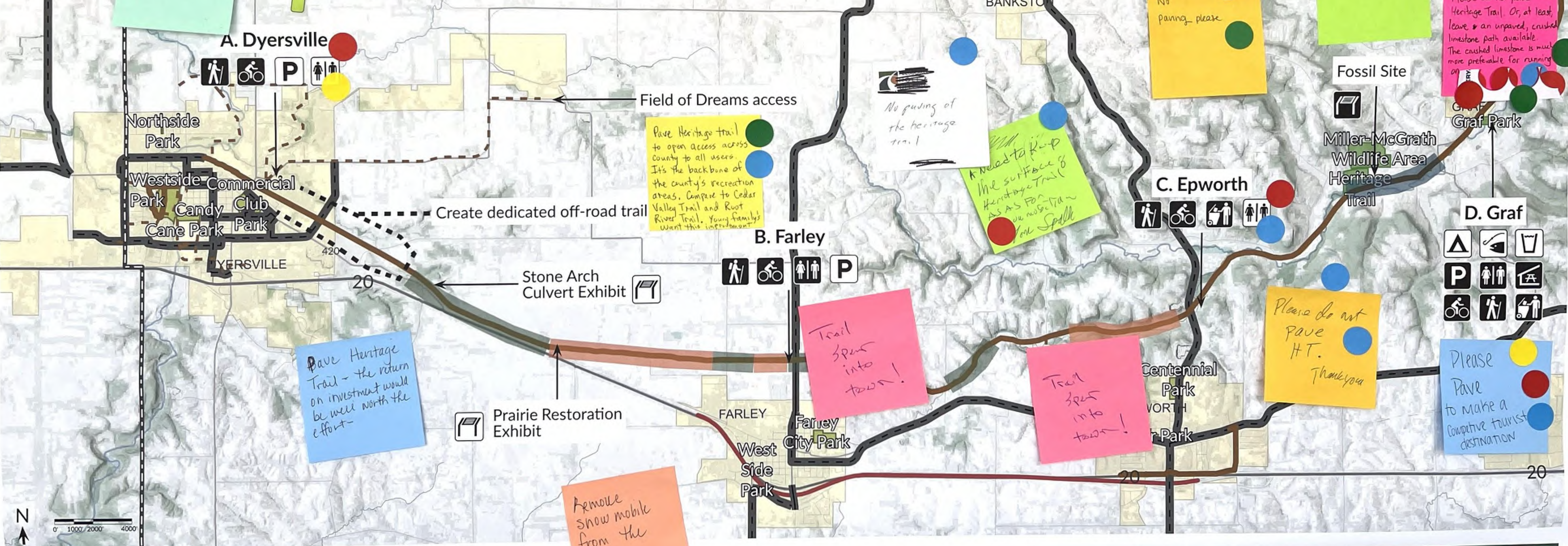 The map displays the Dyersville area, highlighting several parks (such as Northside Park and Prairie Restoration Exhibit) and trails with routes marked. Colorful sticky notes indicate additional information and instructions related to certain locations, including reminders and tasks related to the trails and parks. Spatial relationships are illustrated through lines connecting the parks and areas of interest, providing a visual guide to access within the region.