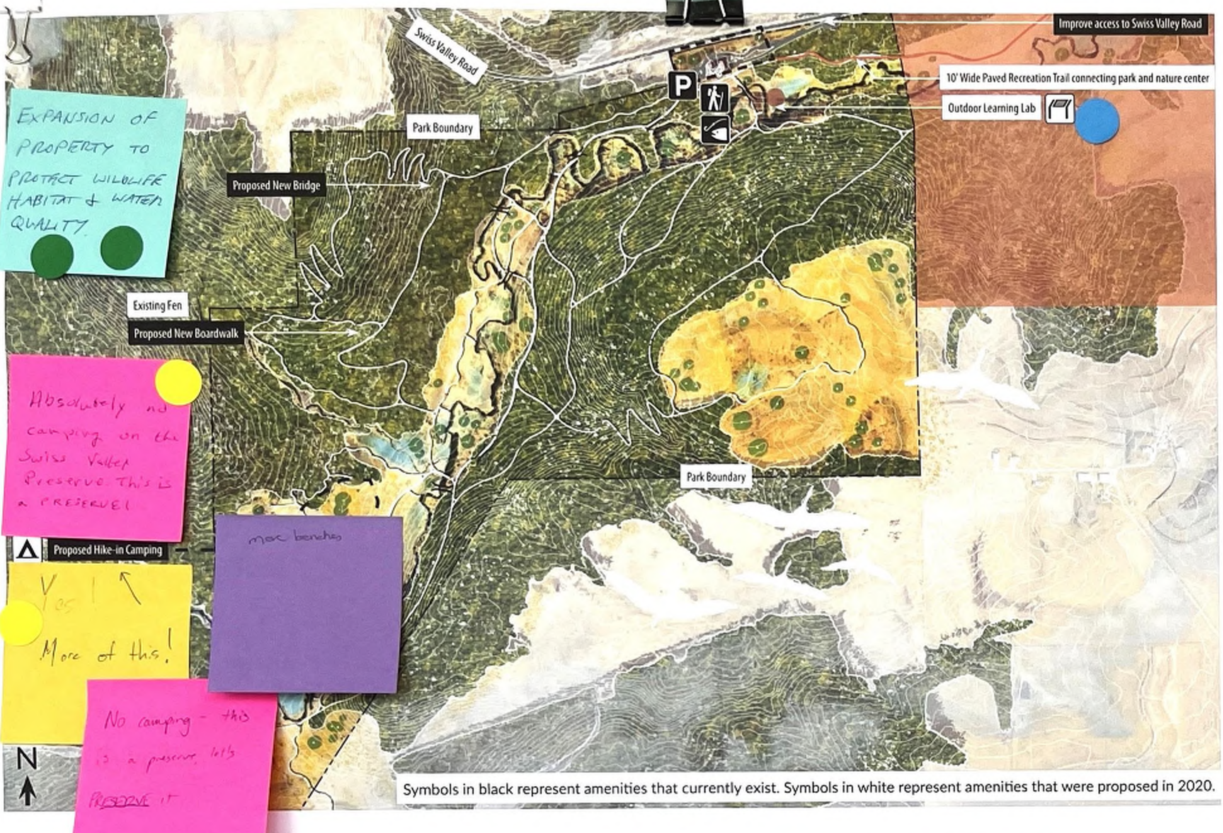 The map displays a park layout featuring the park boundary and symbols indicating existing amenities in black, while proposed amenities from 2020 are shown in white. The map includes color-coded notes that highlight proposed new features, such as a new bridge and boardwalk, along with comments about camping regulations. Symbols suggest hiking trails and other features, enhancing understanding of the area's spatial layout and suggestions for improvement.