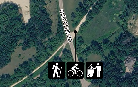 The map features Gun Club Road running through a wooded area. Symbols represent accessibility for hiking, biking, and strollers, indicating the main routes and activities available. The layout shows the road's placement relative to surrounding nature, helping users navigate outdoor options clearly.