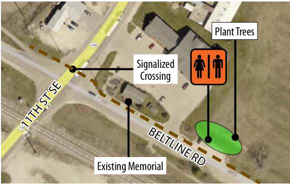 The map depicts a section of Beltline Road and 11th Street SE, highlighting several key features: a signalized crossing for pedestrians, an existing memorial, and areas marked for planting trees. The locations are labeled clearly, showing their spatial relationship to the surrounding roads and landmarks.