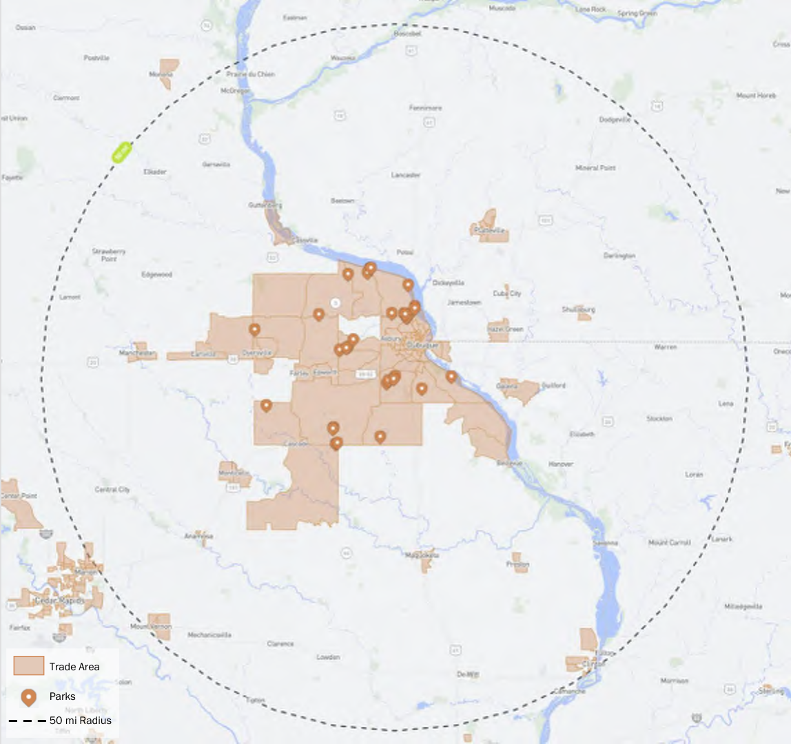 The map displays a trade area outlined in a shaded brown color and markers indicating the locations of parks. A dashed circle represents a 50-mile radius from a central point. The map provides an overview of spatial relationships between parks and the trade area, helping users understand their proximity and distribution.